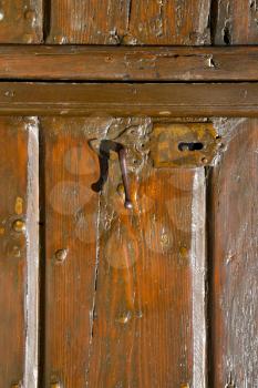 varese  sumirago  abstract   rusty brass brown knocker in a  door curch  closed wood lombardy italy 