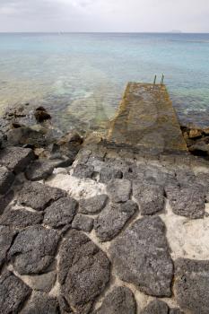 pier rusty chain  water  boat yacht coastline and summer in lanzarote spain
