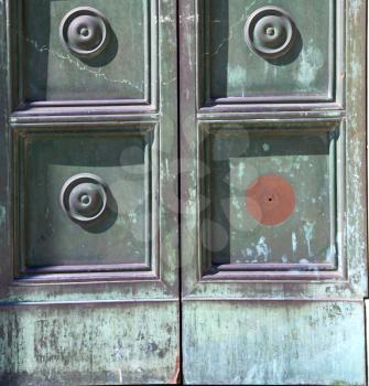 busto arsizio abstract   rusty brass brown knocker in a  door curch  closed wood italy  lombardy  