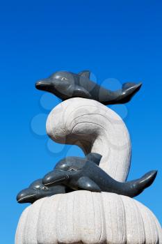   oman musact  old statue of dolphin in the sea and clear sky