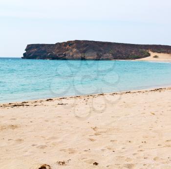near sandy beach sky and mountain  in oman arabic sea  the hill 
