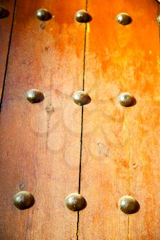 stripped paint in the blue  wood door and rusty    nail