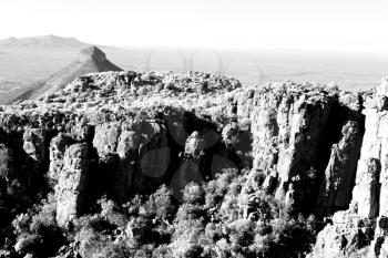 blur   in south africa valley of desolation dirty road rock tree and sky
