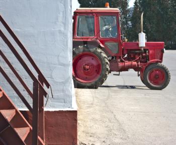 the red tractor resting in a white wall