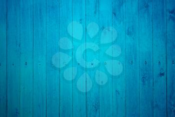Part of wooden fence with tightly fastened new boards painted in blue color