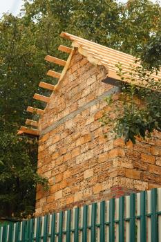 Fragment of an unfinished building a shed with large blocks of limestone on the background of trees