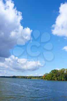 Beautiful cloudy scenery over the river in early autumn. Vertical