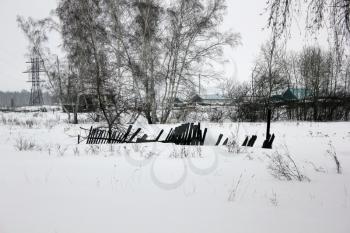 Snow-covered old village rotten fence 30103