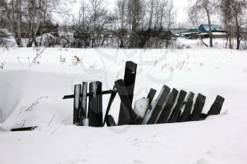 Snow-covered old village rotten fence 30105