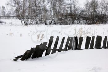Snow-covered old village rotten fence 30107