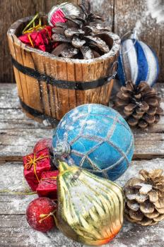 Decorative wooden tub filled with Christmas ornaments and pine cones