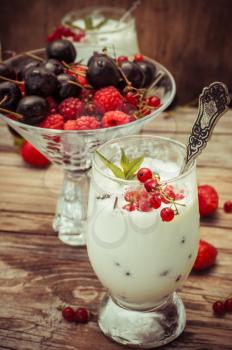 sweet dessert of ice cream per glass and fresh berries, cherries,currants,strawberries.Photo tinted.