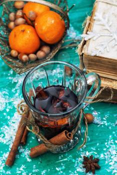 glass of mulled wine,old books and basket of ripe tangerines