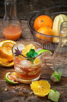fresh juice of tropical citrus fruits on wooden background in rustic style.Selective focus