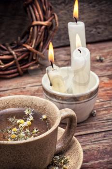 fragrant chamomile tea and burning candles in rustic style.Selective focus