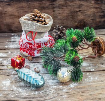 Christmas bag with pine cones on wooden snowy background