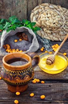 Clay mug with medicinal decoction of sea buckthorn and honey