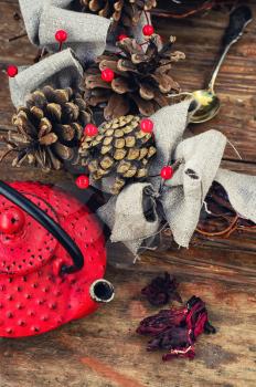 Retro red cast iron kettle and cane wreath with cones