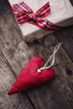 Handmade fabric heart with gift box on wooden background.Photo low key.Selective focus