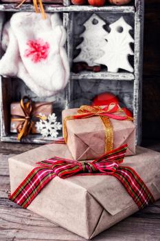 Gift boxes with bow on background of decorations with mittens and Christmas trees in the box