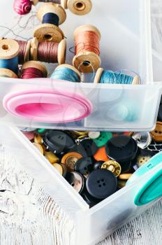 Two plastic sewing box with threads and buttons.Selective focus