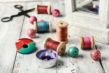 Beads and spools of thread for needlework on bright background