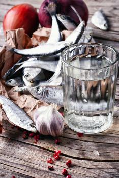 Glass of vodka,smoked sprat,spices in a rustic traditional russian style