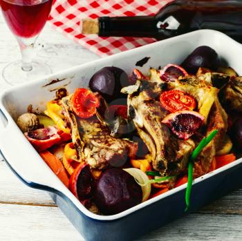 Baked meat with vegetables in a red wine