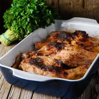 Baked chicken in a porcelain form on a rustic recipe
