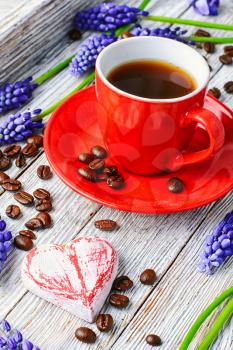 Red coffee cup on a wooden tray covered with flowers of hyacinth