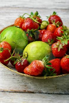 Harvest rustic strawberry and lime fruit on light background