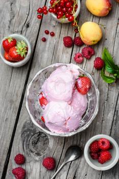 Ice cream with berries currants and strawberries on wooden background