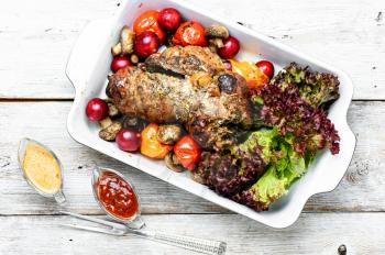 Twisted meatloaf with veal in plum sauce and vegetables in baking dish