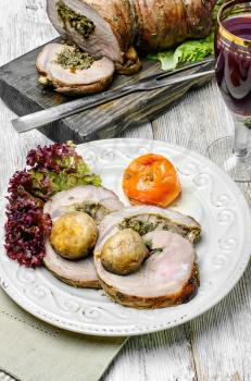 Meatloaf sliced on kitchen board with ketchup and vegetables