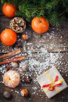 Branch of pine,tangerines,cinnamon on background of Christmas decorations