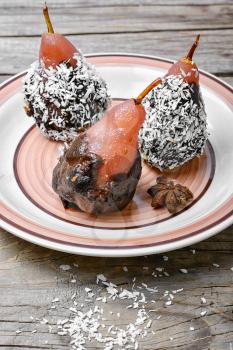Dessert of pears with chocolate syrup and coconut flakes