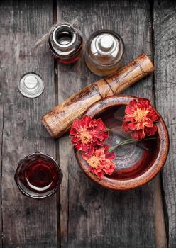 Mortar with healing flowers, plant marigolds and pestle