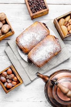 Walnut pastries and stylish copper kettle on table