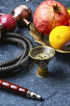 Eastern smoking hookah and dish with pomegranate and lime
