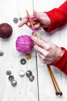 Female hands with knitting needles and balls of wool