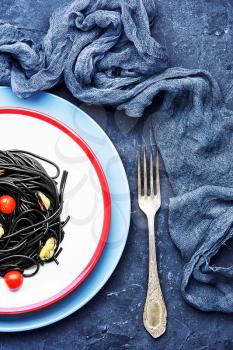 plate of spaghetti with black mussels and tomatoes