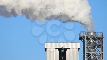 White smoke from the chimney pipe on blue sky background. Industry factory environment ecology pollution
