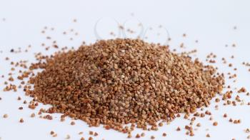 Pile of buckwheat on white background. Agriculture food raw seed. Closeup macro photo
