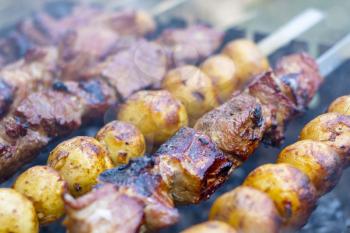Barbecue shish kebab cooking. Grill potatoes dinner cook. Tasty food BBQ background. Roasted fresh beef meat