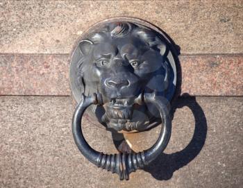 Metal Lion head with ring on granite wall