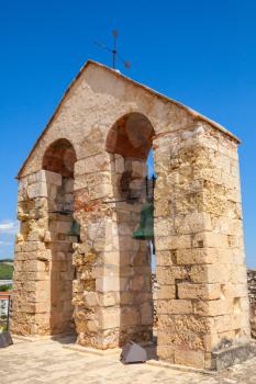 Medieval stone castle in Calafell town, Spain. Two bells hanging in arches