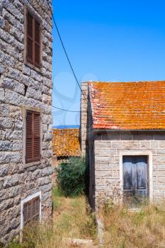 Figari, South Corsica. Rural architecture example. Old houses made of stones with red tile roofs, wooden doors and windows