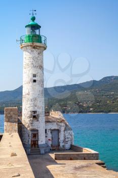 White lighthouse tower with green top. Entrance to Propriano port, Corsica island, France