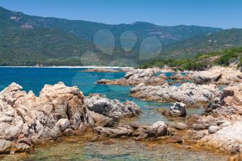 South Corsica, wild coastal landscape with stones in blue sea water. Selective focus on a foreground