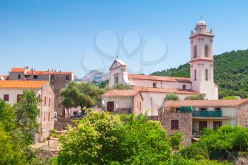 Small Corsican town landscape, old living houses with red tile roofs and bell tower. Piana, South Corsica, France